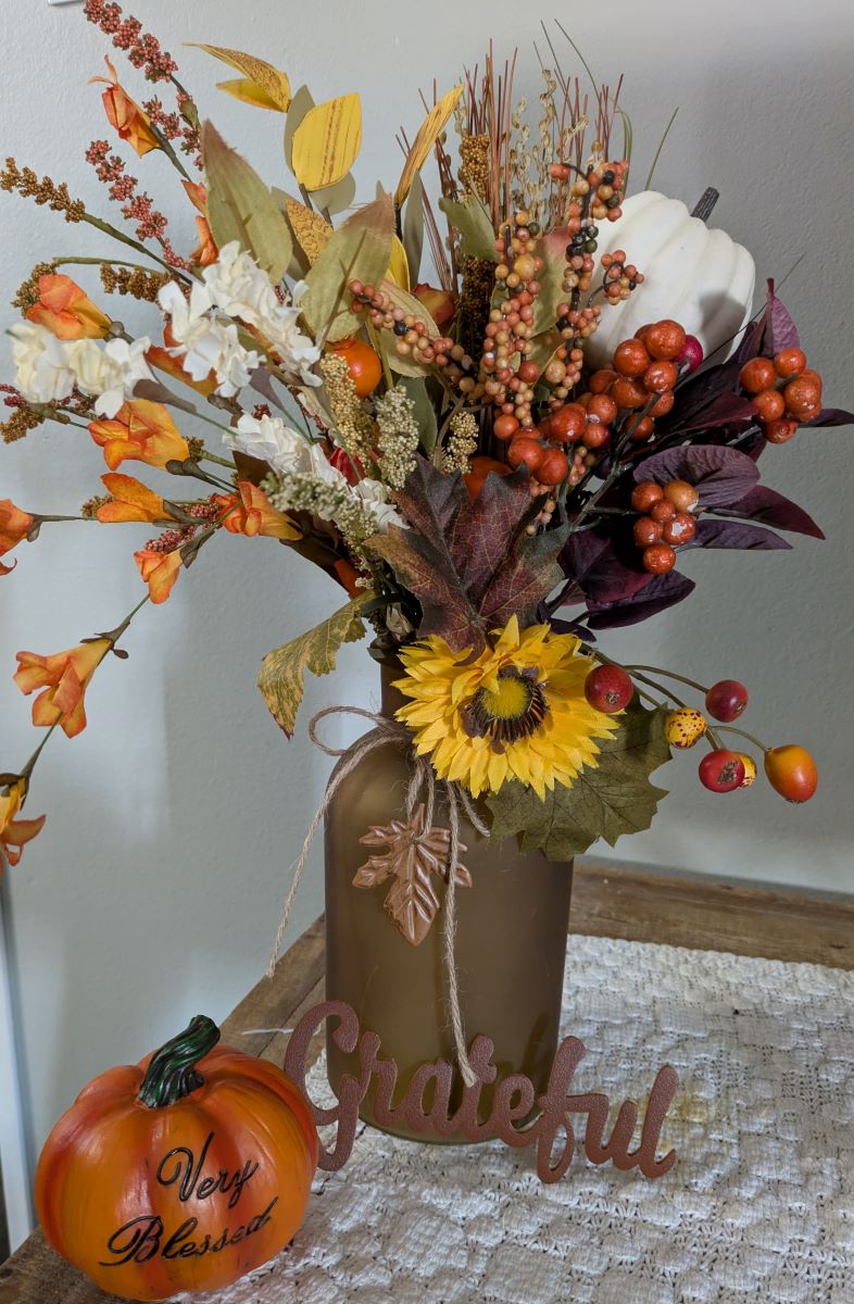 Vase with fall flowers and word grateful